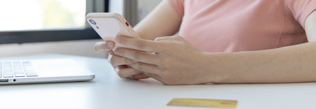 Close-up image of woman's hand holding a phone or smartphone For internet and entertainment or to relax after working in the office, Technology communication and internet networking.の写真素材