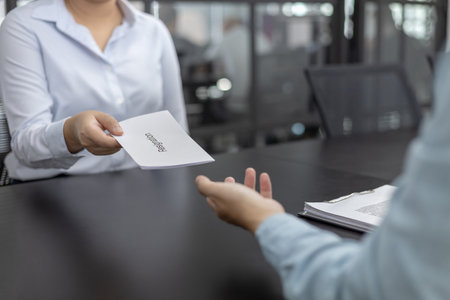 Employee submits the resignation letter envelope to the head of personnel, Carrying a box of work equipment home, Can't bear the burden or pressure, Employment contract is expired.の写真素材