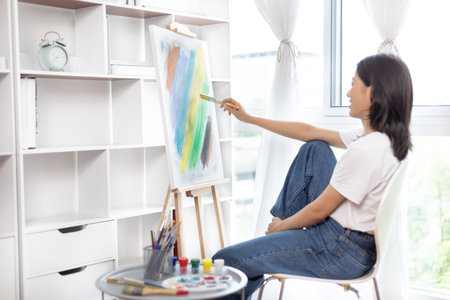 Female artist painting on canvas, Artist studio interior, Draw with watercolor, Drawing supplies , Painting and creativity, Use a brush to draw a pattern by stripes, Artwork, Using Paint Brush.の写真素材