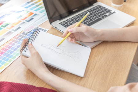 Professional female designer sketches of clothes through laptop in the design studio, Fashion designer, Creativity and ideas, Mannequin, Shirt sketch, Color scheme, Garment accessories ,Freelance.の写真素材