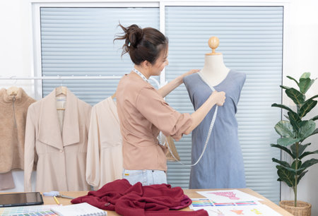Professional female designer sketches of clothes through laptop in the design studio, Fashion designer, Creativity and ideas, Mannequin, Shirt sketch, Color scheme, Garment accessories ,Freelance.の写真素材