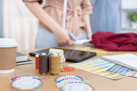 Professional female designers use a tape measure around the shirt mannequins in the studio, Fashion...