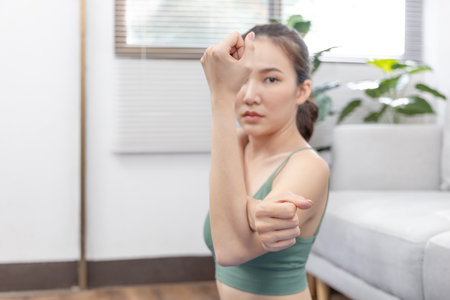 Slim Asian woman doing yoga meditation at home, Stretching the muscles of the body and practicing proper breathing, Yoga studio, Wearing sportswear, Healthy lifestyle, Exercise concept.の写真素材