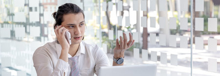 Finance workers are reviewing the company's financial data on a laptop and using smartphones to...