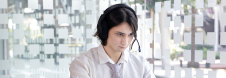 Businessman are greeting friends and manager through video chats and use headphones for communication and business conversations, Online communication, New normal, VDO Call, Internet learning.の写真素材