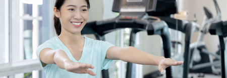 Beautiful and shapely Asian woman working out in the gym, Play exercise machine treadmill, Dumbbell,...