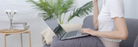 Beautiful Asian woman uses laptop to communicate work, Working from home at home happily, Freelancers work or learn in private rooms at home, Online communication, Home lifestyle.の写真素材