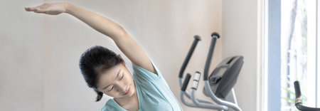 Beautiful and shapely Asian woman working out in the gym, Play exercise machine treadmill, Dumbbell,...