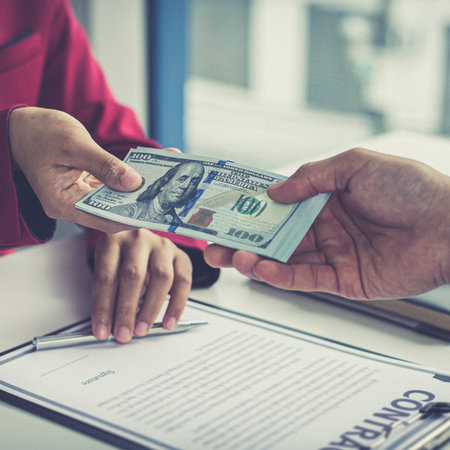 Businessmen give dollars to bribe employees in signing contracts to buy illegal land and real estate, Business fraud and social injustice, corruption and bribery concept.の写真素材