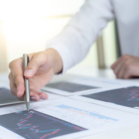 Accountants and financiers are brainstorming the analysis of revenue performance with stock graphs...