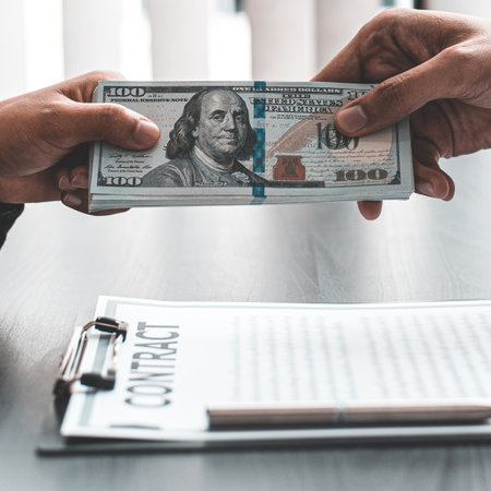 Businessmen give dollars to bribe employees in signing contracts to buy illegal land and real estate, Business fraud and social injustice, corruption and bribery concept.の写真素材