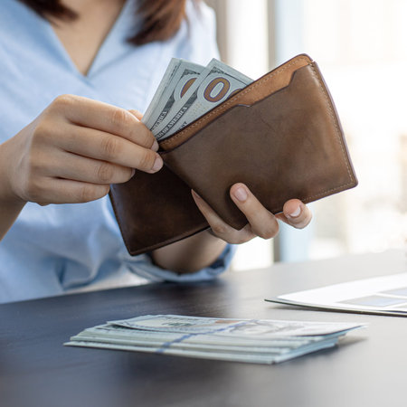 Businessman with a brown purse and a 100 dollar banknote, Saving money and spending using cash...