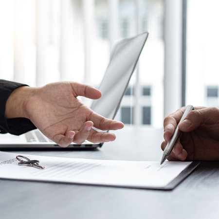 Real estate agent or sales manager has proposed terms and conditions to customers who sign house purchase agreements with insurance, Agreement to sign the purchase contract concept.の写真素材