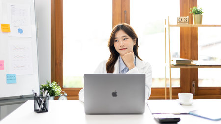 Businesswoman using laptop to work, Asian woman working in the office, Financial clerk or accountant with documents and equipment working on the desk, Using computers for financial transactions.の写真素材
