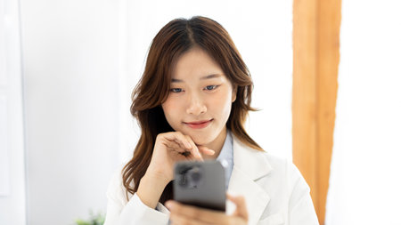 Finance workers are reviewing the company's financial data on a laptop and using smartphones to communicate or chat with the team during  social distances, Talk on the phone or video call.の写真素材