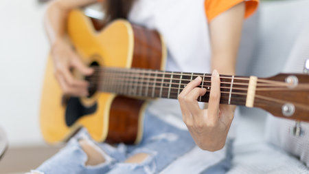 Close up fingers playing guitar strings, Strum to make a sound, Acoustic guitar, Catching guitar chords to create music, Music therapy and meditation practice with playing the guitar.の写真素材