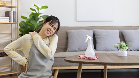 Housewife with back pain and shoulder pain from doing hard housework on weekends, Big cleaning, Housework, Daily routine , Cleaning spray and rags, Spray alcohol, Clean up.の写真素材