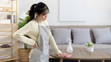 Housewife with back pain and shoulder pain from doing hard housework on weekends, Big cleaning, Housework, Daily routine , Cleaning spray and rags, Spray alcohol, Clean up.の写真素材