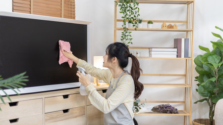 Housewife is cleaning things and Storage cabinet or showcase in the living room, Big cleaning, Housework, Daily routine ,Removes germs and dirt and deep stains, Spray alcohol, Clean up on weekends.の写真素材