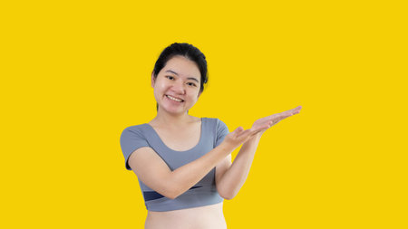 Asian woman with holding copyspace imaginary on the palm to insert an ad, Showing copyspace pointing, Showing her hand to present something on white background.の写真素材