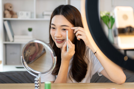 Beautiful women with social media influences are teaching makeup and use cosmetics, In front of the camera to recording vlog video live streaming, Online business on concept of beauty bloggers.の写真素材