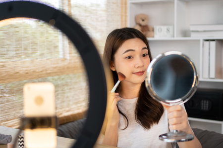Beautiful women with social media influences are teaching makeup and use cosmetics, In front of the camera to recording vlog video live streaming, Online business on concept of beauty bloggers.の写真素材