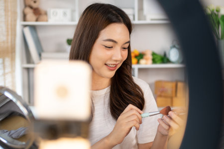 Beautiful women with social media influences are teaching makeup and use cosmetics, In front of the camera to recording vlog video live streaming, Online business on concept of beauty bloggers.の写真素材