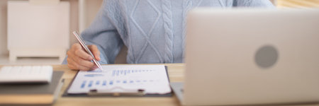 Woman analyzes data graphs, Works intently in his personal office, Employees working in the office, Businesswoman working in front of laptop.の写真素材