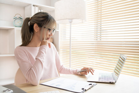 Young woman using a laptop, Work from the comfort of home, Use your laptop for work and communication, Work from home.の写真素材