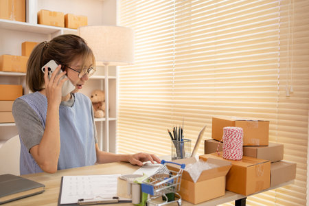 Sell products online, Business owner on the phone talking to a customer, Packaging and Delivery, Packaging and Shipping.の写真素材
