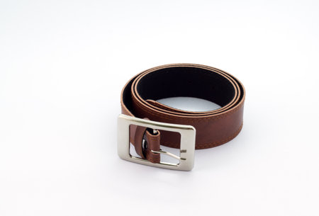 Brown leather belt with buckle on white backgroundの写真素材