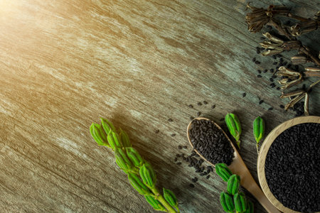 Heap of black Sesame seeds in wooden spoon on old wooden background.Top view.の写真素材
