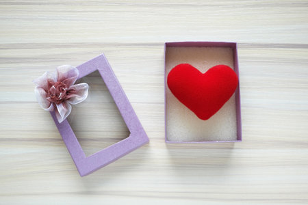 Red heart inside gift box for Valentines Day,on wooden table. Top view.の写真素材