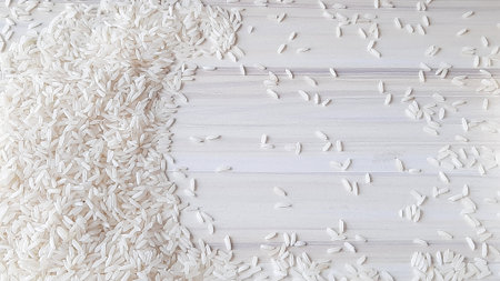 Rice grains on white wooden background. Top view, copy spaceの写真素材