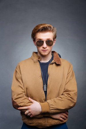 portrait of a young man on a gray background denim jacketの写真素材
