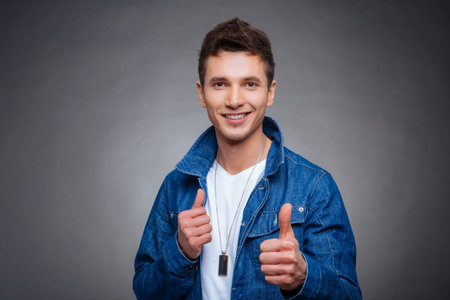 portrait of a young man on a gray background denim jacketの写真素材