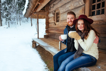 Happy couple drinking tea and wood old houseの写真素材