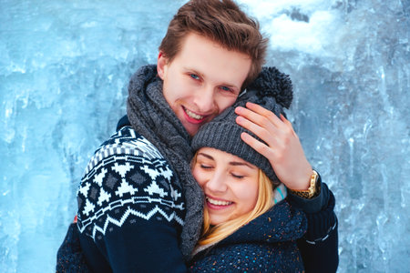 Winter couple piggyback in snow smiling happy and excited. Beautiful youngcouple close upの写真素材