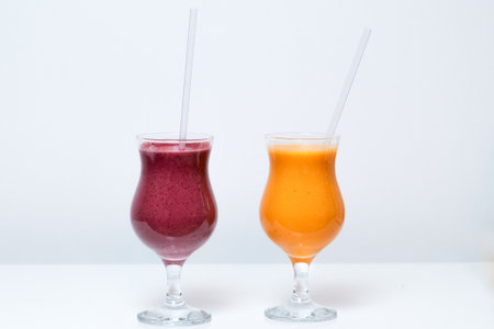 A glass of orange juice and fresh fruits on whit backgroundの写真素材