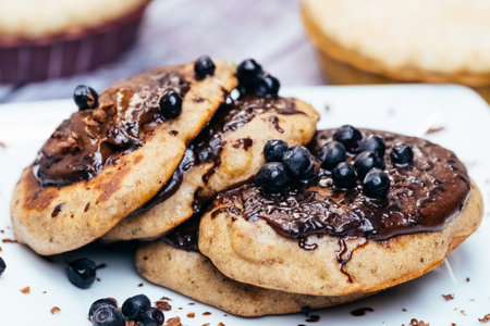 Pancakes stuffed with blueberry jam and sprinkled with blueberries on white plate.の写真素材