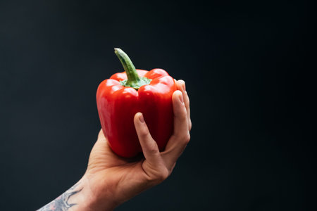 Paprika in hand on dark backgroundの写真素材