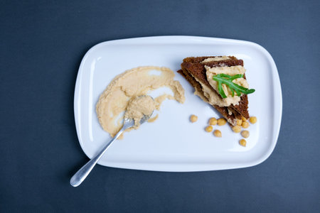 Plate of hummus on wooden table, top view