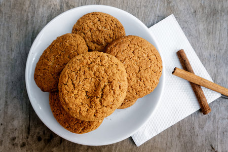 Oatmeal cookies with raisin are on a wooden table. Cookies are made in house conditions