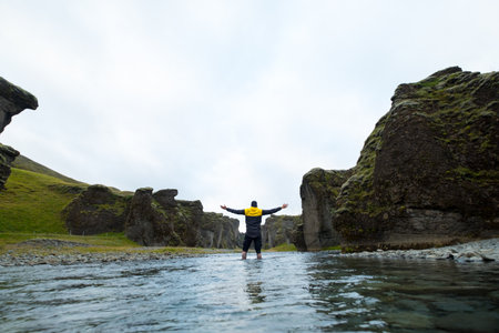 Man on a mountain. The guy, put his hands up to the sky. Freedom and unity with nature. Sun going down. Tourist outdoors enjoying the scenery.の写真素材