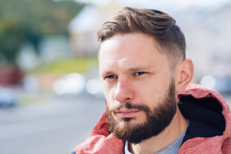 young guy with a beard and mustache posing on the street. handsome beard, outdoor portrait, hipster man.の写真素材