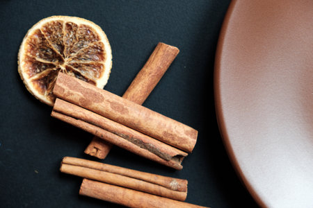 Dry slices of citrus on the background of black slate, cinnamon and aniseの写真素材