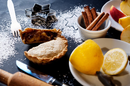 Apple pie delicious tart with nuts and on a black background and ingredients of which in turn it is cooked. Close up.の写真素材