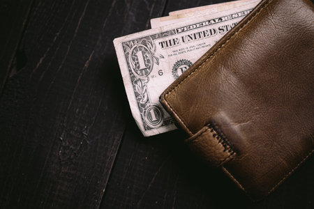 Old money bills in a vintage wallet. Flat lay of travel wooden desk