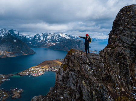 Hiker with backpack enjoying sunset landscape in Lofoten Norwayの写真素材