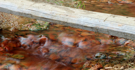 Bridge over small red rock brookの写真素材